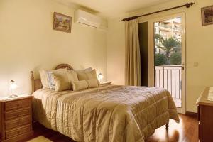 a bedroom with a large bed and a window at Palheiro Residence Familiar 2 in Funchal