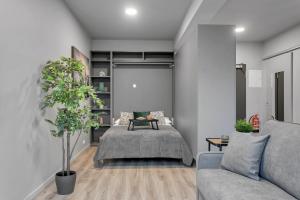 een slaapkamer met een bed en een bank bij Sunny Central Apartment in Reykjavík