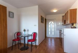 una cucina con un tavolo e sedie rosse in una stanza di Studio apartment in Novalja with sea view, terrace, air conditioning, WiFi 3565-7 a Novalja (Novaglia)