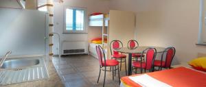 kuchnia ze stołem i czerwonymi krzesłami w pokoju w obiekcie Apartment in Novalja with sea view, terrace, air conditioning, WiFi 3565-12 w Novalji +36 zdjęć