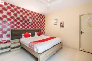 1 dormitorio con 1 cama con pared roja en OYO Hotel Golden Inn Near Cubbon Park en Bangalore