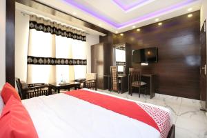 um quarto com uma cama grande e uma sala de jantar em OYO Hotel Ska Hometel em Chandīgarh