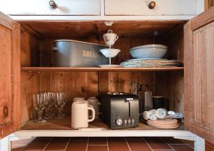 a kitchen shelf with a toaster and other kitchen items at Haus Krauterkasten in Naumburg +40 photos