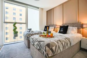- 2 lits dans une chambre d'hôtel avec des boissons et des fruits sur un plateau dans l'établissement Luxury Apartment - City Centre - Free Parking, Fast Wifi, Sky TV and Netflix by Yoko Property, à Milton Keynes