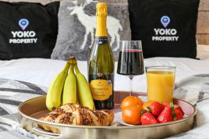 a tray of fruit and a bottle of wine on a bed at Luxury Apartment - City Centre - Free Parking, Fast Wifi, Sky TV and Netflix by Yoko Property in Milton Keynes