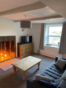 a living room with a couch and a coffee table at Brook Cottage in Holmfirth