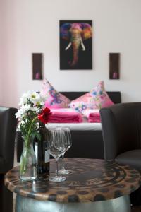 a table with two wine glasses and a couch at Café & mehr in Halle an der Saale