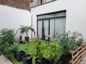 een tuin met planten in potten naast een gebouw bij Brand new ROOMS with private bathroom and balcony-terrasse in Brussel