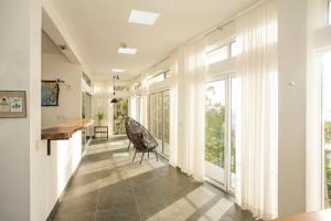 a hallway with a table and a chair and large windows at Camino del Alma Apartments in Bacalar