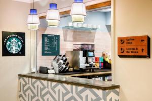 una cafetería con barra y luces colgantes en ibis Styles Bournemouth en Bournemouth
