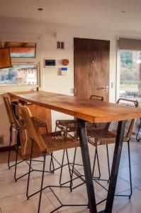 una mesa de madera con sillas en una habitación en Duplex a estrenar a pocos metros del gutierrez en San Carlos de Bariloche