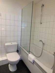 a white toilet sitting next to a bath tub at Hotel Au Quartier in Maastricht