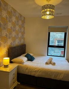 a bedroom with two beds and a lamp and a window at Galway Horizon Apartment in Galway