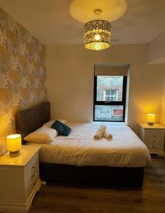 a bedroom with two beds and a chandelier at Galway Horizon Apartment in Galway