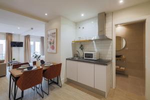 a kitchen and dining room with a table and a microwave at Apartamentos Magna Sevilla in Seville