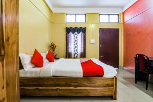 um quarto com uma cama grande e almofadas vermelhas em OYO Alohi Ghar em Bhutiāgāon