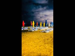 een groep stoelen en parasols op een strand bij Port Said Resort rentals nO2 in `Ezbet Shalabi el-Rûdi
