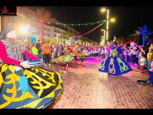 een groep mensen die dansen in een straat op een festival bij Port Said Resort rentals nO2 in `Ezbet Shalabi el-Rûdi