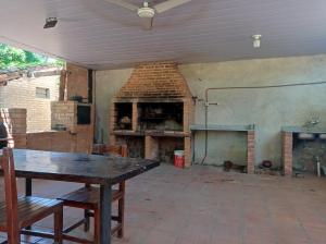 a patio with a table and a brick fireplace at Hotel La Aparesida in Areguá