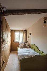 ein Schlafzimmer mit einem grünen Bett und einem Fenster in der Unterkunft Haus Krauterkasten in Naumburg