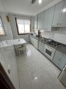 - une cuisine blanche avec une table et une cuisinière dans l'établissement Valterra Vigo, à Vigo