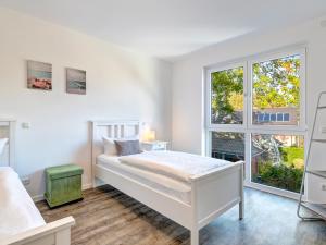 ein weißes Schlafzimmer mit einem Bett und einem Fenster in der Unterkunft Bernsteinquartier BQ0554 Lieblingsplatz in Ostseebad Kölpinsee