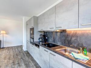 eine Küche mit weißen Schränken und einem Waschbecken in der Unterkunft Bernsteinquartier BQ0554 Lieblingsplatz in Ostseebad Kölpinsee