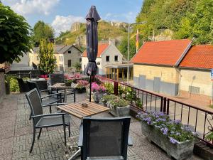 a patio with tables and chairs and an umbrella at Pension Auberge de Dael in Valkenburg