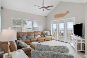uma sala de estar com um sofá e uma televisão de ecrã plano em Paradise Villa em Ocean Isle Beach