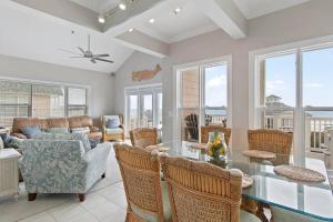 uma sala de estar com uma mesa de vidro e cadeiras em Paradise Villa em Ocean Isle Beach