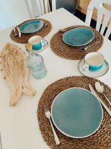 a table with plates and utensils on it at Monte Azul Penthouse in Ribeira Grande +12 photos