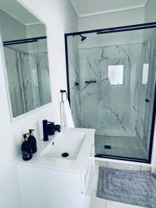 uma casa de banho branca com um lavatório e um chuveiro em 745@TheBlyde em Pretoria