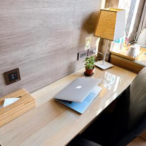 einen Schreibtisch mit einem Laptop darüber in der Unterkunft DLInn Hotel in Taichung