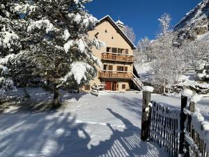 een groot huis in de sneeuw met een hek bij Inspiration Montagne Chambre d'hôtes in Névache