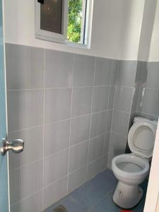 a bathroom with a toilet and a window at Romblon Transient House in Romblon