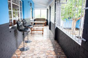 un portico con sedie, tavolo e finestre di BLUEBERRY BED AND BREAKFAST a Pietermaritzburg