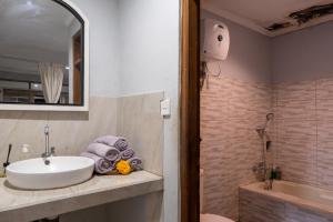 烏布的住宿－普納瑪別墅酒店，浴室配有盥洗盆和浴缸。