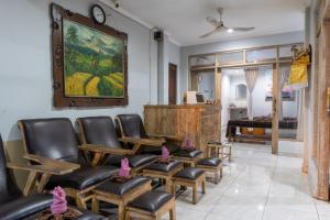 a waiting room with leather chairs and a piano at Purnama House in Ubud
