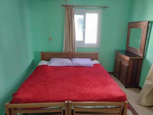 a bedroom with a red bed with a window and a mirror at Farsha View in Sharm El Sheikh