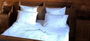 a bed with white sheets and white pillows at Inspiration Montagne Chambre d'hôtes in Névache