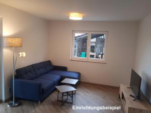 a living room with a blue couch and a window at Hof Schütterle in Friedrichshafen