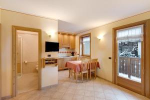 cocina y comedor con mesa y TV en Baita Pemont en Livigno