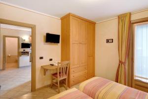 1 dormitorio con 1 cama y 1 mesa con silla en Baita Pemont en Livigno