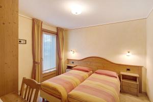 1 dormitorio con 2 camas y ventana en Baita Pemont en Livigno
