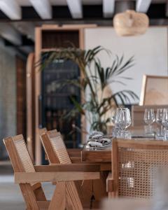 a wooden table and chairs with glasses and a plant at Santa Lucia Maccarese - Residenza Agricola in Maccarese
