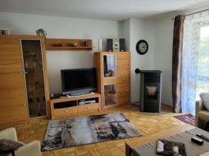 a living room with a flat screen tv and wooden furniture at Ferienpark im schönen Falkenstein 7 in Falkenstein