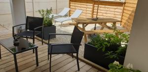 un patio avec des chaises et une table sur une terrasse dans l'établissement Gîte Les Pommes de Pin aux Mathes La Palmyre 4 pers, aux Mathes