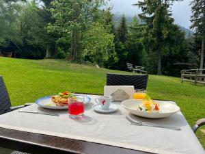 a table with two plates of food and drinks on it at Hotel OHMA - Casa Viorel in Poiana Brasov