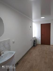 um quarto vazio com um lavatório e uma porta em SunRay Guest House-Hostel em Karakol