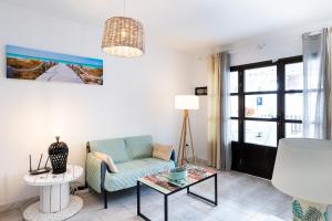 a living room with a couch and a table at Casa Piquel in Corralejo +16 photos